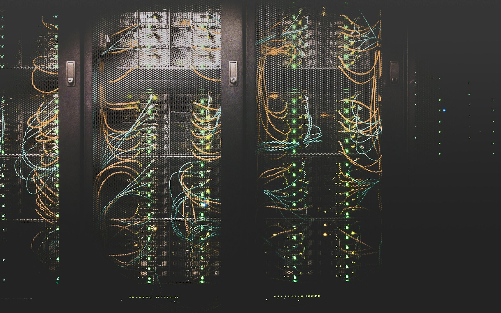 Server cabinets with green status lights in a dark data center