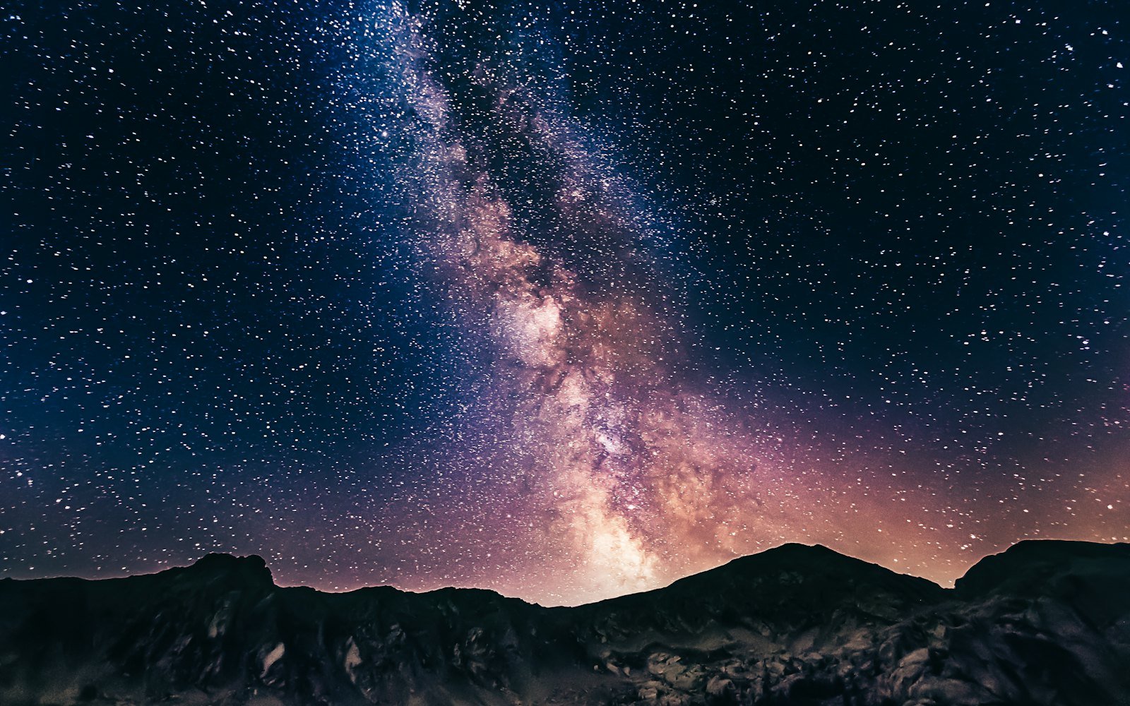 Milky Way over a dark mountain ridge at night