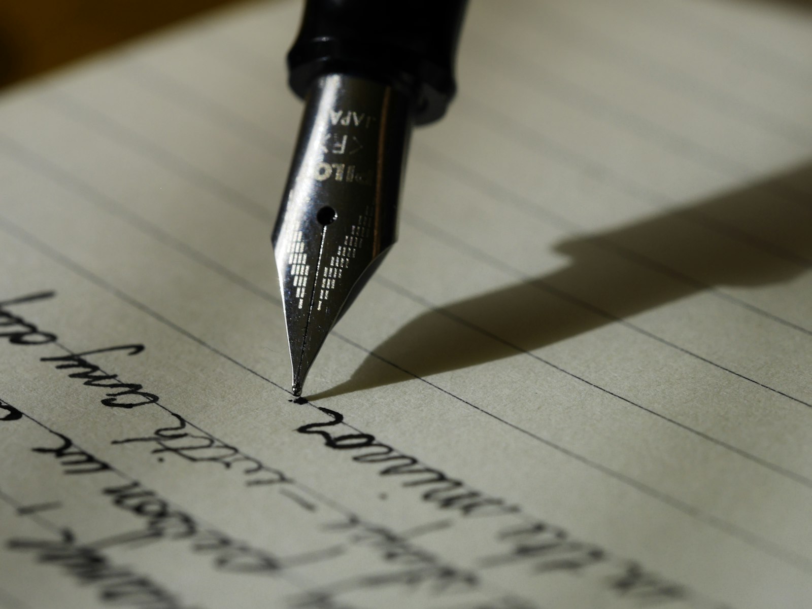 Fountain pen writing on paper in low light